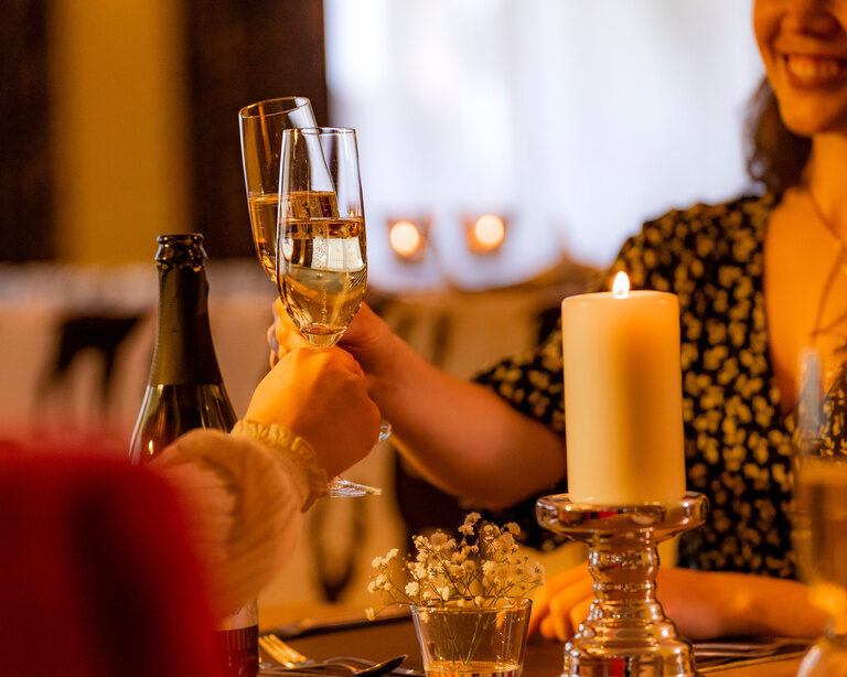 Zwei Personen stoßen mit Sektgläsern an